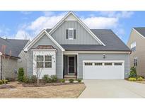 Charming home with gray siding, a two-car garage, and a manicured lawn in a well maintained neighborhood at 1036 Chamblee Ct, Durham, NC 27703