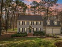 Charming two-story home with black shutters, gray siding, mature trees, and a well-manicured lawn at 1113 Harvest Mill Ct, Raleigh, NC 27610