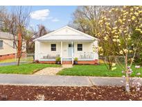 Charming one story home featuring a metal roof, front porch, and landscaped yard at 1234 Berkeley St, Durham, NC 27705