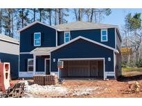 New two-story home featuring a two-car garage and a modern, dark blue exterior at 153 Klamath Dr, Garner, NC 27529