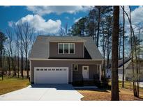 Charming home with gray siding, attached garage and a well maintained lawn on a sunny day at 169 Black Cloud Dr, Louisburg, NC 27549