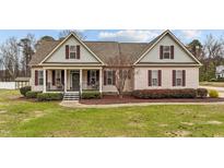 Charming single-Gathering home featuring a well-manicured lawn, landscaped garden, and inviting porch at 225 Woodfield Ct, Fuquay Varina, NC 27526