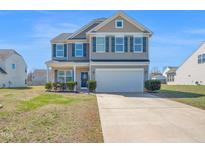 Charming two-story home with well-maintained lawn and inviting curb appeal on a sunny day at 2741 Rains Dr, Haw River, NC 27258