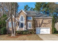 Traditional two-story brick home with a white front porch and attached two-car garage at 315 Barthel Dr, Cary, NC 27513