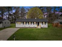 Charming single-story home with a well-maintained lawn and a classic white brick facade at 409 Avery St, Garner, NC 27529