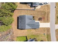 Aerial view of a home with a driveway and lawn, showing the roof and surrounding landscape at 96 Foxtail Ct, Clayton, NC 27520