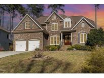 Beautiful two-story brick and stone home with a two-car garage and manicured lawn at 10016 Porto Fino Ave, Wake Forest, NC 27587