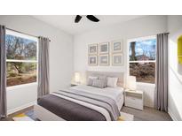 Bright bedroom features a modern ceiling fan, a stylish bed, and serene outdoor views through the windows at 1012 W Webb Ave, Burlington, NC 27217