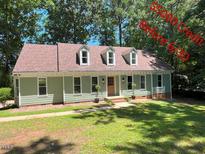 Charming light green single-story home featuring a new brown roof and manicured lawn with mature trees at 1116 Shadywood Ln, Raleigh, NC 27603