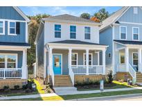 Charming two-story home featuring a welcoming front porch, complemented by a vibrant blue door and neat landscaping at 113 Weavers Grove Dr, Chapel Hill, NC 27514