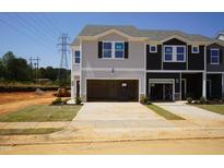 Charming new construction townhomes featuring attached garages and craftsman-style design with black and gray accents at 1165 Abbott St, Mebane, NC 27302
