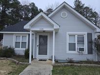 Charming home featuring light gray siding, a cozy front porch, and well-maintained landscaping at 225 Sebastian Way, Rocky Mount, NC 27804