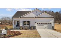 Charming single-story home with white siding, stone accents, and an attached two-car garage at 228 Pecan Valley Way, Four Oaks, NC 27524