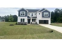 Beautiful two-story home with blue and gray siding, manicured lawn, and open two-car garage at 245 Golfview Ave, Benson, NC 27504