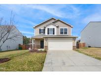 Charming two-story home with neutral siding, a two-car garage and a well-maintained front yard at 2527 Girvan Dr, Fuquay Varina, NC 27526
