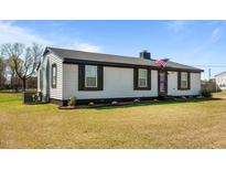 Charming one-story home with black shutters, landscaped yard, and an American flag at 3005 Lewy Ln, Rocky Mount, NC 27801