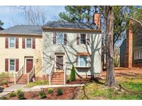 Charming townhome with green siding, brown shutters, brick steps, and mature trees at 3207 Coachmans Way, Durham, NC 27705