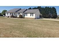 Charming single-story home with attached garage, well-manicured lawn, and mature trees at 3226 Powhatan Rd, Clayton, NC 27527