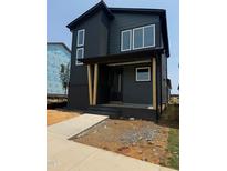 New construction home featuring a dark painted brick foundation and siding with many large windows at 50 Rainfall Dr, Pittsboro, NC 27312