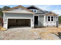 New home with attached garage, light gray siding, covered entry and dark trim at 63 Tee Time Ter, Benson, NC 27504