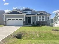 Charming single-Gathering home featuring a two-car garage and lush lawn at 63 Tee Time Ter, Benson, NC 27504