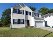 Charming two-story home with a well-maintained lawn and a two car garage at 701 Marjam Ln, Fuquay Varina, NC 27526