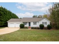 Charming one-story home with a two-car garage and well-manicured lawn at 7329 Blannie Farms, Willow Springs, NC 27592