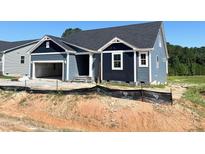 New construction home featuring blue siding, a dark roof, and an attached two-car garage at 79 Tee Time Ter, Benson, NC 27504