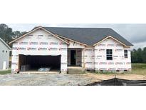 Unfinished exterior of a one story home showing construction wrap, window and door openings, and an attached two car garage at 79 Tee Time Ter, Benson, NC 27504