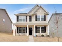 Charming two-story home with black shutters, a covered porch, and a well-maintained lawn at 829 James J Freeland Memorial Dr, Hillsborough, NC 27278