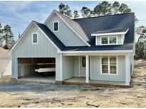 Charming exterior showcasing light blue siding, a welcoming front porch, and an attached two-car garage at 8487 Old Us 421, Lillington, NC 27546