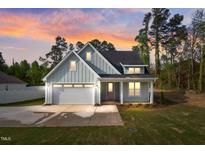 Charming craftsman-style home with a two-car garage, pretty yard, and welcoming front porch at 8487 Old Us 421, Lillington, NC 27546