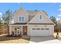 Charming two-story home featuring a 2-car garage, landscaped yard, and craftsman details at 934 Woodland Rd, Creedmoor, NC 27522