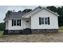 Charming single-story home featuring white siding, black shutters, and a stone foundation at 9600 Stallings Rd, Spring Hope, NC 27882