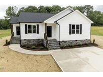 Charming new construction home with white siding, black shutters, and stone foundation accents at 9600 Stallings Rd, Spring Hope, NC 27882