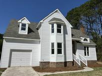 Charming two-story home with white siding, gabled roof, and attached garage at 100 Wiley Oaks Dr, Wendell, NC 27591