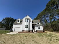 Inviting two-story home featuring white siding, brick accents, and a well-manicured lawn at 100 Wiley Oaks Dr, Wendell, NC 27591