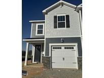 New construction home with gray siding, white garage door, and stone accents on the lower level at 11 Silver Pne Dr, Angier, NC 27501
