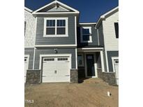 Charming townhome featuring a one-car garage, stylish gray siding, and a welcoming front entrance at 13 Silver Pne Dr, Angier, NC 27501