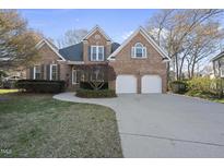 Charming brick home boasts a well-manicured lawn and a two-car garage with a spacious driveway at 1301 Merrington Cir, Raleigh, NC 27615