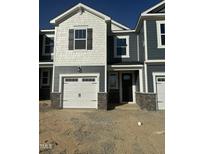 Charming townhome featuring a white garage door, stone accents, and a mix of shingle and horizontal siding at 17 Silver Pne Dr, Angier, NC 27501
