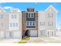 Modern townhome showcasing a stylish brick and gray facade with an attached one car garage and manicured lawn at 1917 Fishamble St, Fuquay Varina, NC 27526