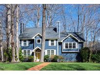 Charming two-story home with blue siding, white trim, a brick pathway and a well-maintained lawn at 201 Adams Way, Chapel Hill, NC 27516