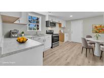 Bright kitchen boasts stainless steel appliances, white cabinets, and an eat-in dining area at 2080 Saint Paul Church Rd, Roxboro, NC 27574