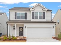 Charming two-story home featuring a two-car garage, complemented by a well-manicured front lawn at 3504 Triad Ct Ct, Raleigh, NC 27604