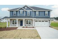 Charming two-story home showcasing blue siding, decorative shutters, and an attached two-car garage at 410 Hopewell Branch Ct, Smithfield, NC 27577