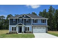 Charming two-story home with a two-car garage, complemented by well-manicured lawn at 410 Hopewell Branch Ct, Smithfield, NC 27577