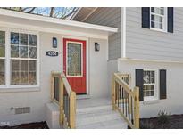 Charming home's front entrance featuring a bright red door, brick facade, and lovely decorative glass at 4204 Green Rd, Raleigh, NC 27604