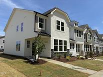 Row of new construction two-story homes with manicured lawns and welcoming curb appeal on a sunny day at 6401 Granite Quarry Dr, Raleigh, NC 27610