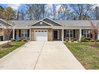 Charming townhome with brick facade, attached garage, and well-manicured front yard and mature trees at 818 Houston Ct, Haw River, NC 27258
